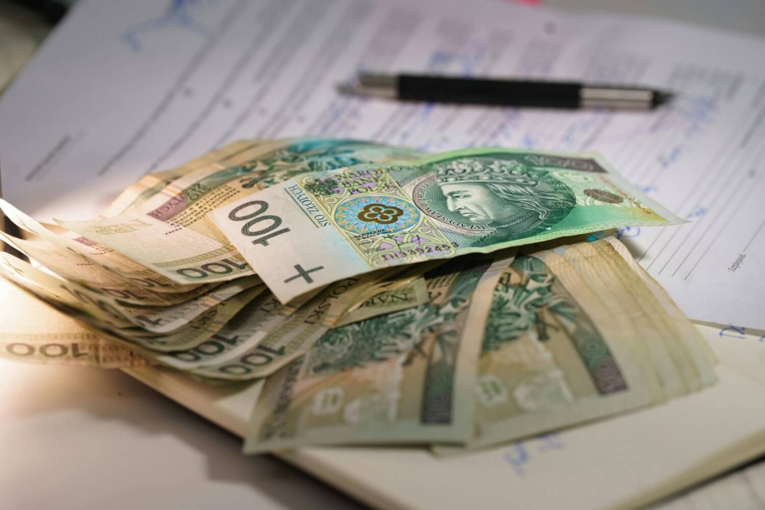 Dokumenty i pieniądze leżą na stole