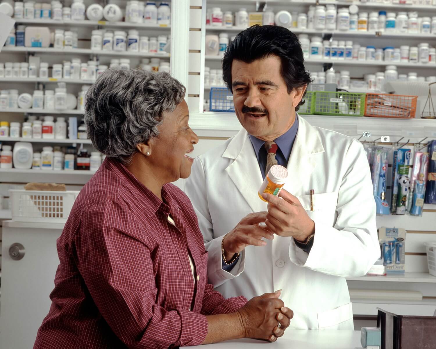 Farmaceuta pokazujący produkty kobiecie w aptece