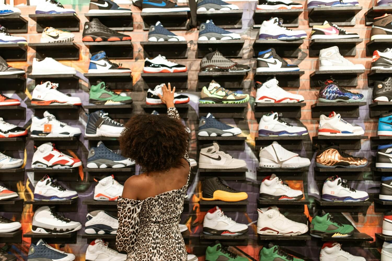 Kobieta oglądająca sneakersy w sklepie z butami