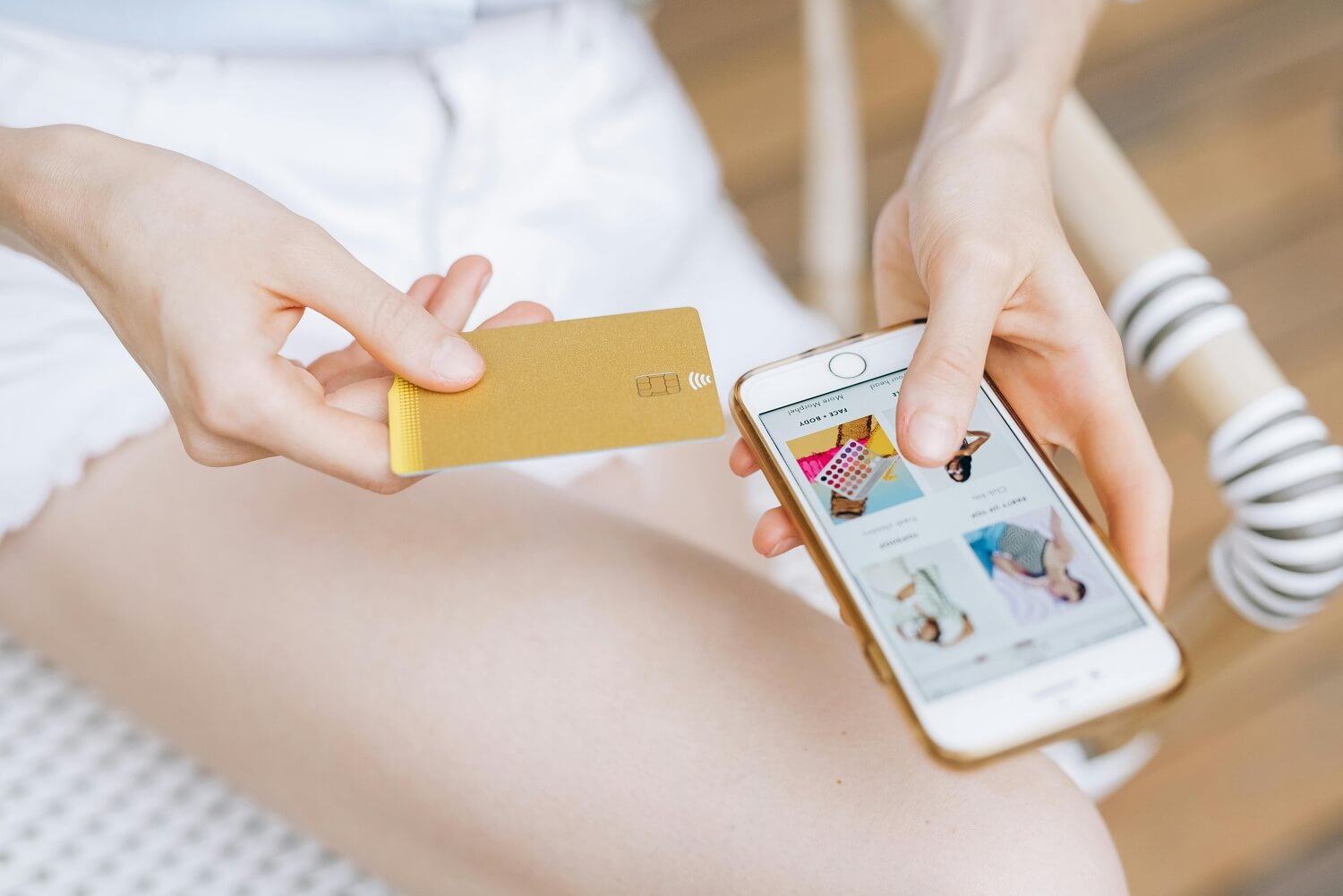 Kobieta trzymająca kartę płatniczą robiąc zakupy na smartfonie