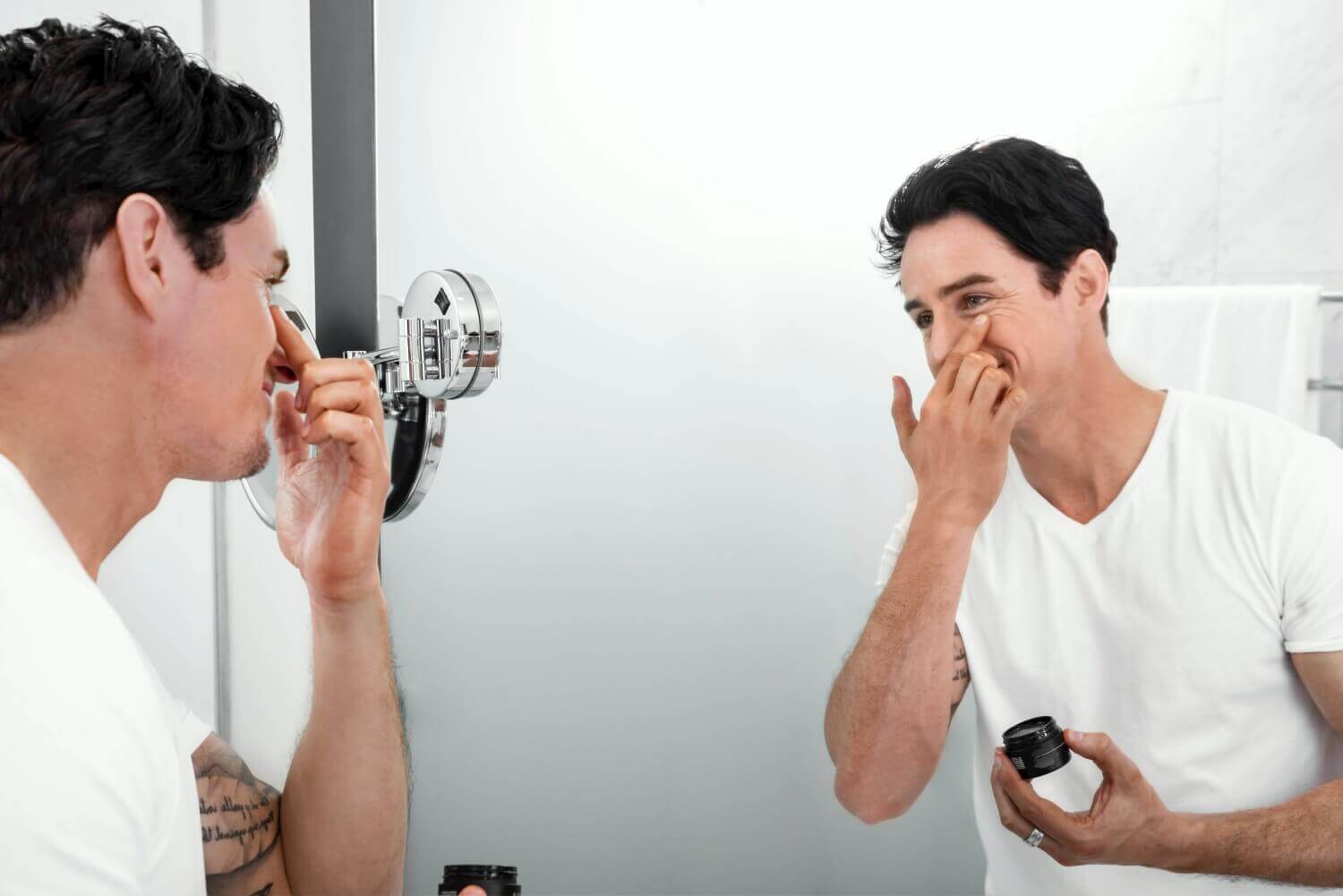 Mężczyzna nakładający krem na twarz w łazience