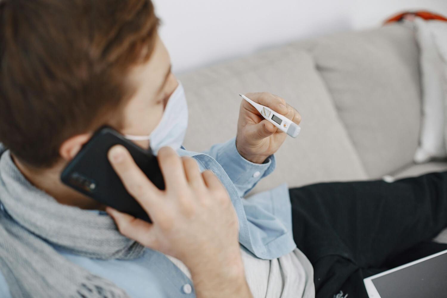 Mężczyzna w maseczce korzystający z teleporady medycznej